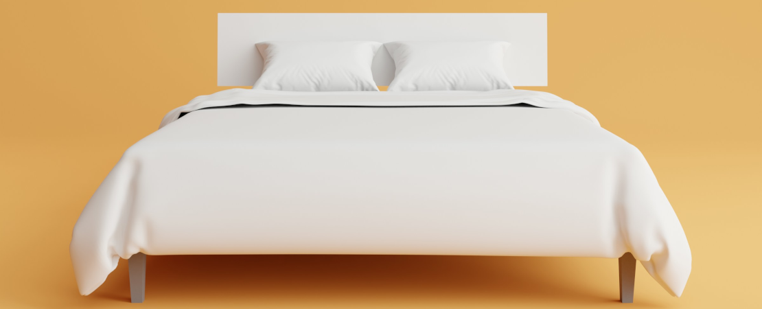 White double bed against yellow wall.