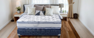 Navy and white mattress in a neutral coloured bedroom.
